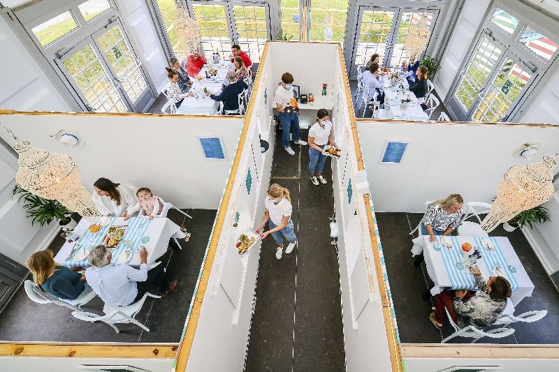 Diners are seated in family bubbles to test the UK's only purpose built pop-up socially distanced restaurant, split into separate dining pods with serving hatches under one marquee, where staff are training for dinner service in preparation ahead of reopening to guests when the lifting of further lockdown restrictions in England comes into effect on Saturday, at the Anti Social Club, in Polzrath, Cornwall, England, Friday July 3, 2020. (Photo by Ben Birchall/PA Wire via AP Photo)